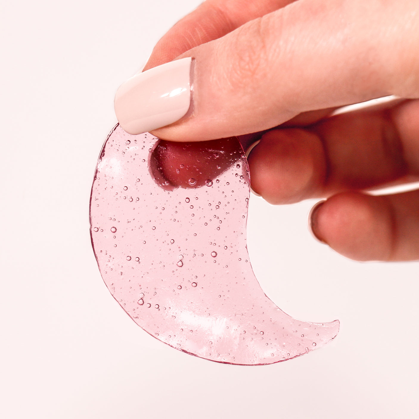 hand holding a rose under eye gel