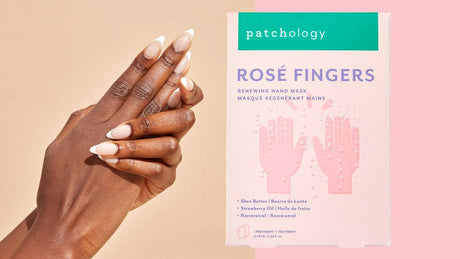 Patchology Rosé Fingers renewing hand mask box with manicured hands on soft pink and beige background
