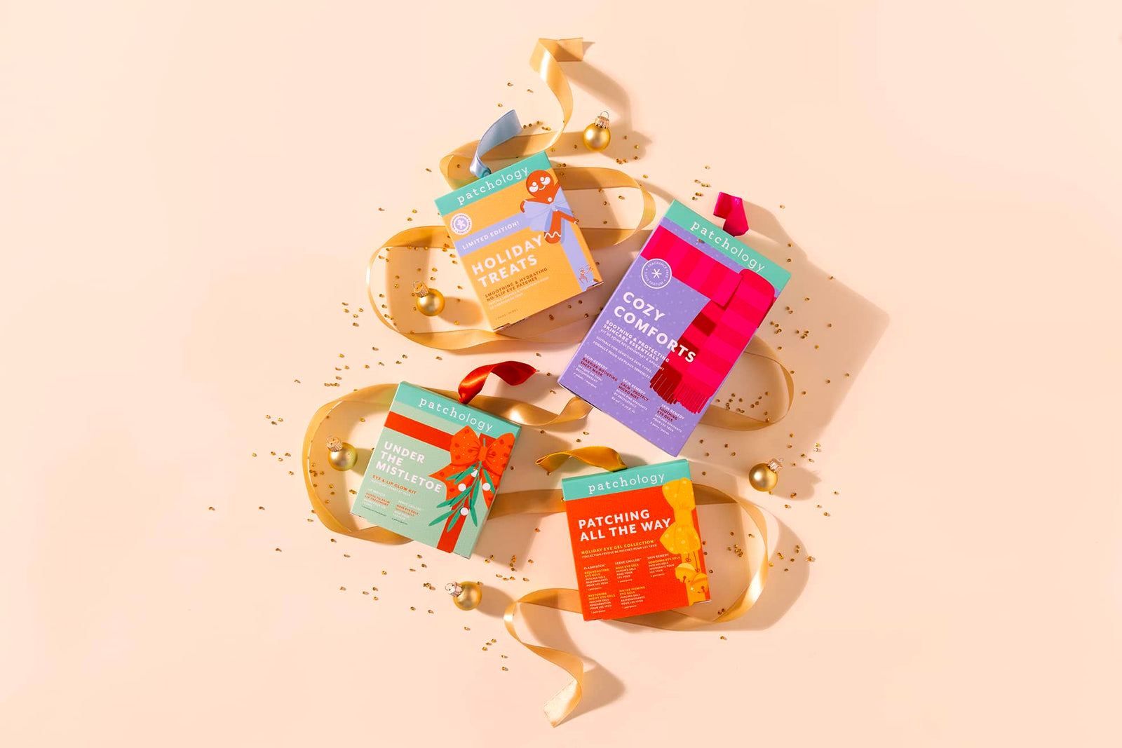Patchology holiday skincare gift sets with colorful boxes and gold ribbons on festive beige background