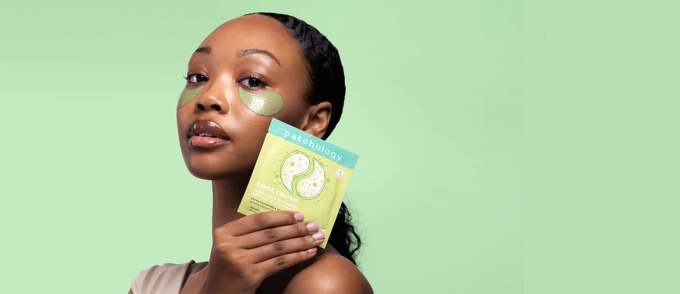 Woman holding a package of eye patches with a green background