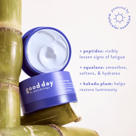 An open jar of good day by Patchology facial cream showing the white cream inside, styled with green bamboo stalks on a light background with product benefits text.