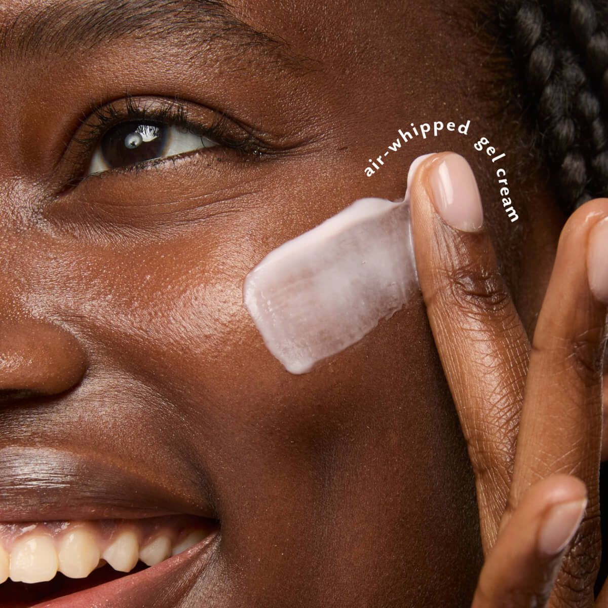 Smiling woman applying Nine-to-Five Instant Wake-Up Morning Gel-Cream to her cheek.