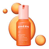 Good Day Glow Potion Illuminating Superfood Serum in a 28 mL bottle, featuring a vibrant orange body and a light pink cap, set against a dark green background with abstract orange liquid splashes.