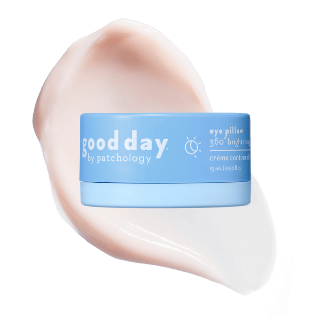Blue jar of Eye Pillow 360° Brightening Eye Cream displayed over a pale peach cream swatch.