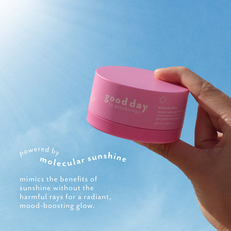 Hand holding Nine-to-Five Instant Wake-Up Morning Gel-Cream against a bright blue sky, highlighting molecular sunshine for a radiant, mood-boosting glow.