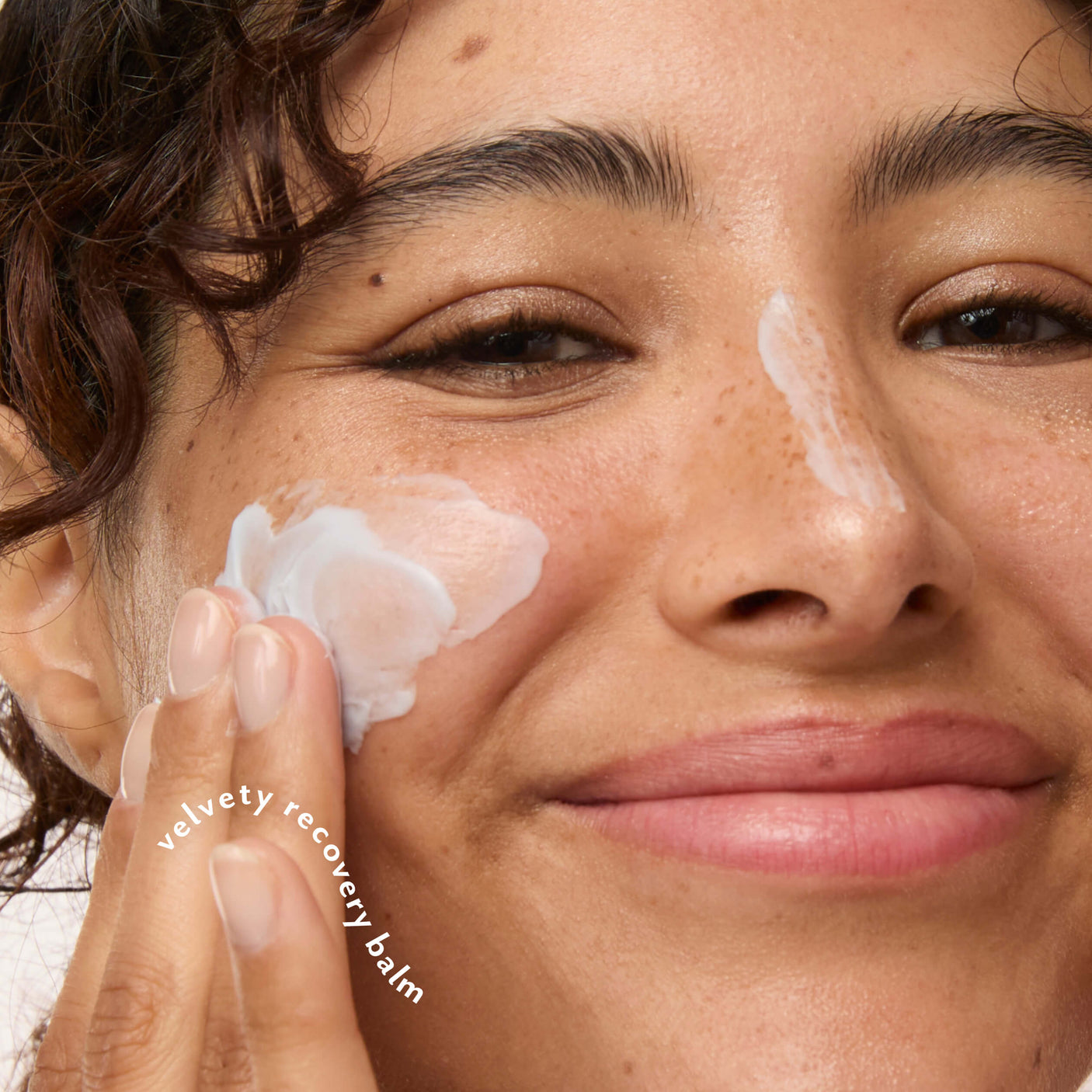 Woman applying Five-to-Nine Dreamy Overnight Recovery Balm to her cheek.