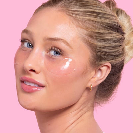 Woman wearing clear hydrogel under-eye patch, glossy finish for hydrating, smoothing, and brightening tired under-eyes
